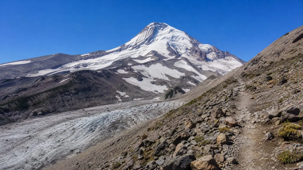 A rocky ridge trail above a glacier on the northeast side of Mount Hood