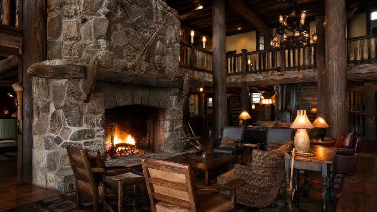 A great stone fireplace and timber beams inside a mountain lodge